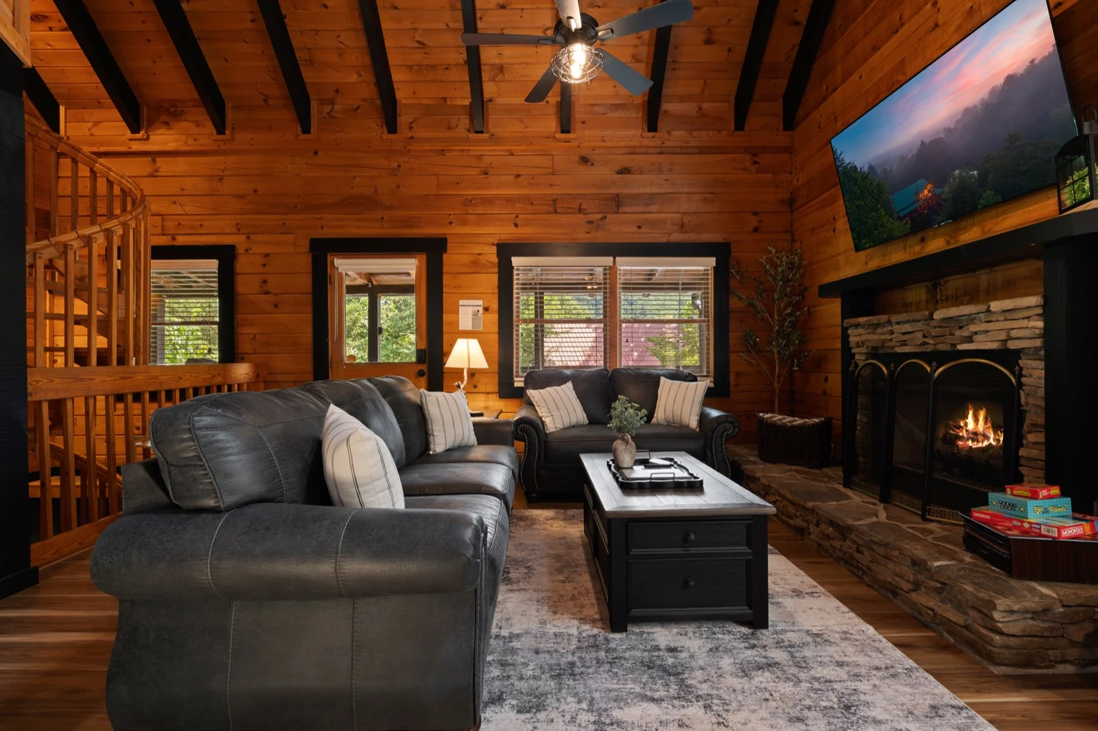 The living room with sofas, fireplace, timber ceiling and stairs